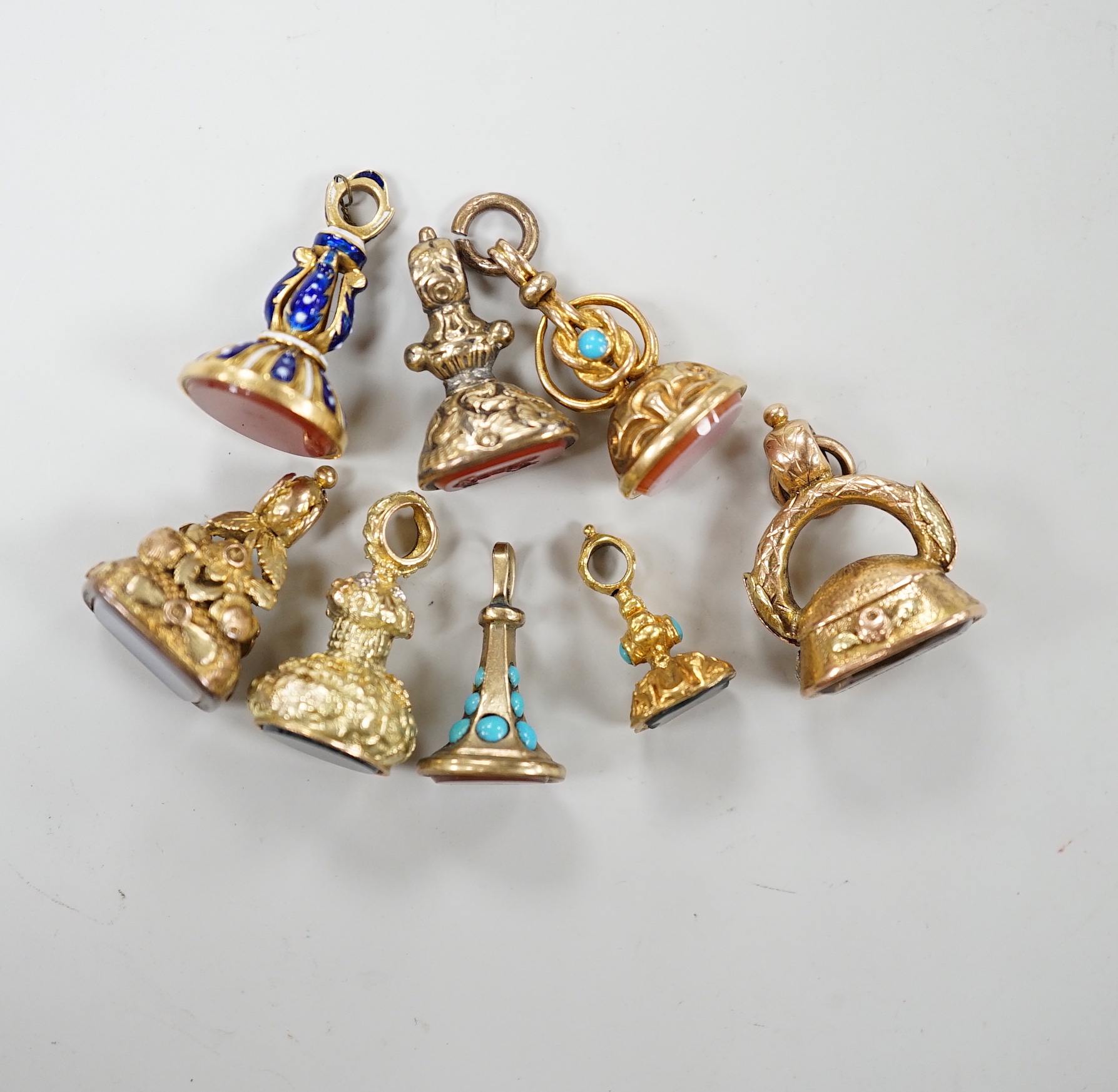 A group of eight assorted 19th century yellow metal overlaid and chalcedony or citrine set fob seals, including two colour, enamelled and turquoise set, largest 20mm.